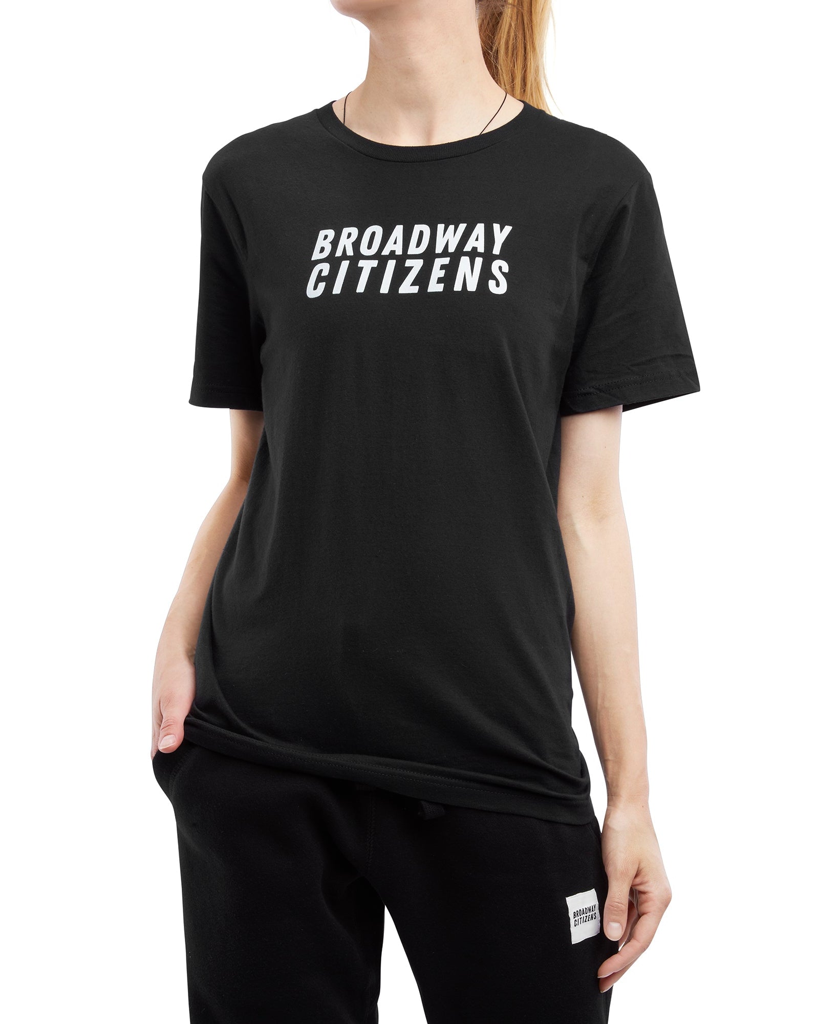 Person wearing a black t-shirt with 'BROADWAY CITIZENS' text on a white background